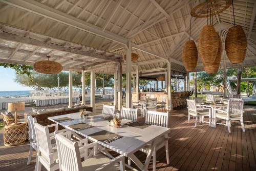 jadalnia na świeżym powietrzu ze stołami i krzesłami oraz plażą w obiekcie Gili Eco Villas w Gili Trawangan
