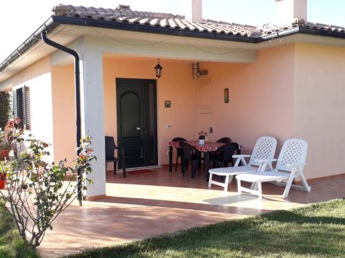 a patio with a table and chairs on it at Residence Ai Campi Da Golf Saturnia in Saturnia