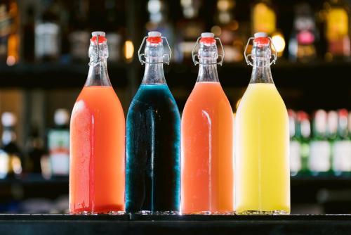 a group of four soda bottles sitting on a bar at SureStay Plus Hotel by Best Western AC LUXE Angeles City in Angeles