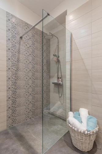 a bathroom with a glass shower with a basket at Apartman Andra in Split