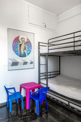 two chairs and a table in a room with bunk beds at Amazing Seafront Apartment Athens Riviera in Athens