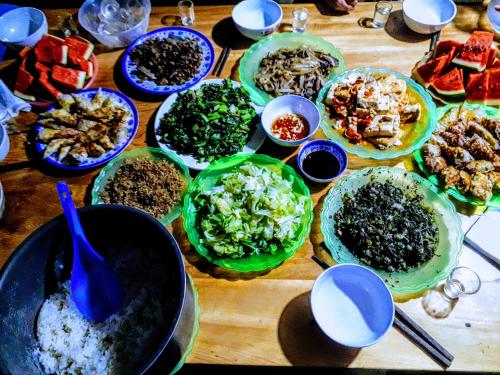 a wooden table with plates of food on it at Surelee Homestay in Sa Pa