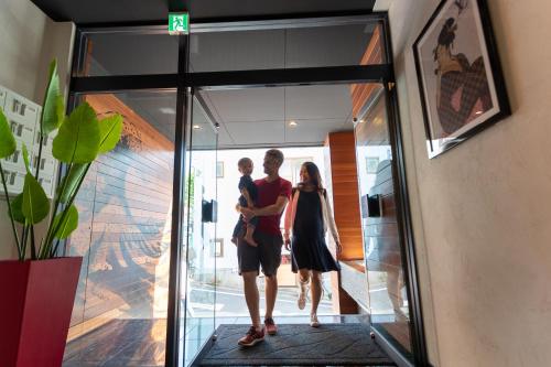 two people are walking through a glass door at Sakura Cross Hotel Shinjuku East in Tokyo