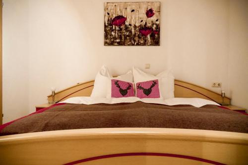 a bedroom with a large bed with two pillows at Haus Alpengluehn in Iselsberg