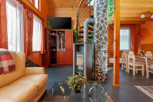 sala de estar con sofá y chimenea en Winter & Summer - Chalets, en Ždiar