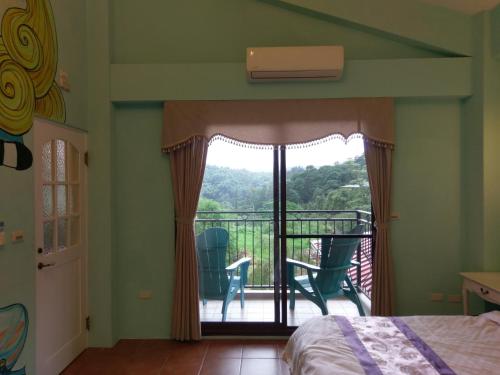 a bedroom with a bed and a balcony with chairs at Bramasole B&B in Puli