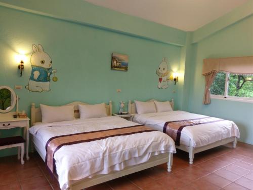 2 Betten in einem Zimmer mit grünen Wänden in der Unterkunft Bramasole B&B in Puli