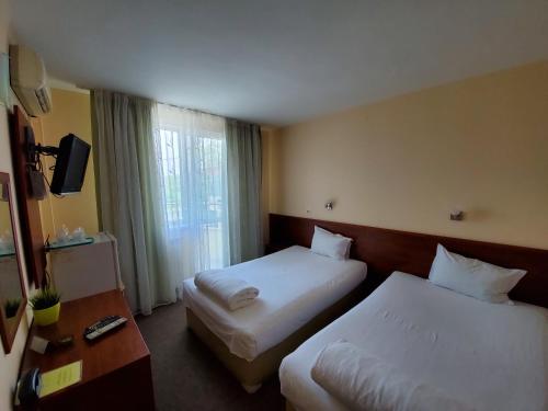 a hotel room with two beds and a window at Hotel Galant in Sofia
