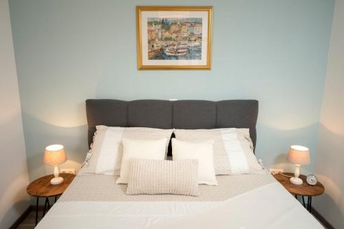1 dormitorio con 1 cama con sábanas blancas y 2 lámparas en Holiday Home Belina, en Stari Grad