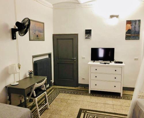 a living room with a tv and a dresser with a desk at I Ninni in Castiglione del Lago