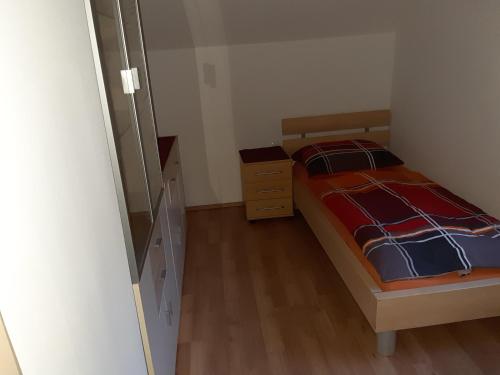a small bedroom with a bed and a dresser at Privatzimmer Roland in Hutten