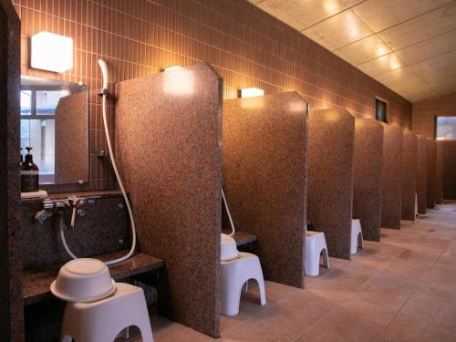 a row of toilet stalls in a public restroom at Iwakuni Kokusai Kanko Hotel in Iwakuni