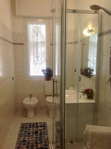 a bathroom with a shower and a toilet and a window at Partenope in Levanto