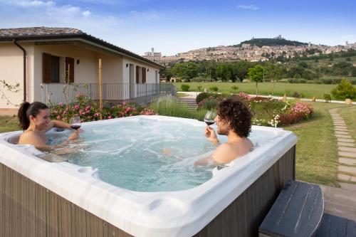 two people in a hot tub in a backyard at All'Antica Mattonata in Assisi