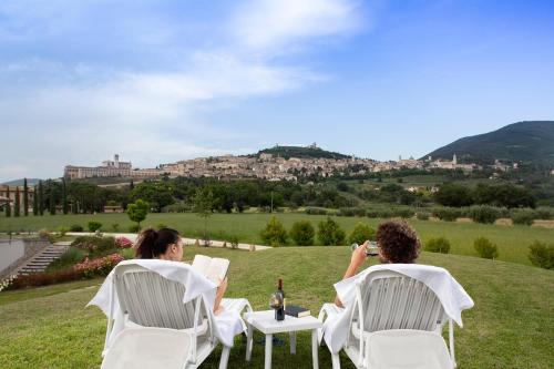 two people sitting in lawn chairs taking pictures of a city at All'Antica Mattonata in Assisi