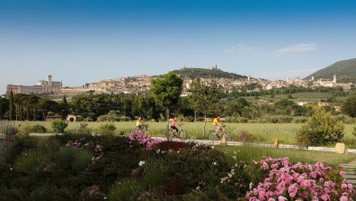 two people riding bikes in a garden with flowers at All'Antica Mattonata in Assisi