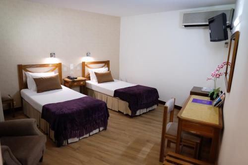 a hotel room with two beds and a table at Hotel Dona Sofia in Braga