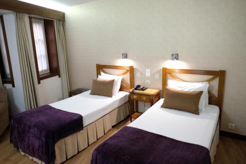 a hotel room with two beds and a telephone at Hotel Dona Sofia in Braga