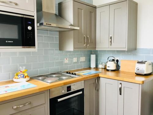 uma cozinha com armários brancos e um forno com placa de fogão em Mount Pleasant Apartments em Beaumaris