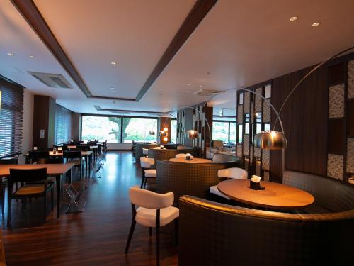 a restaurant with wooden tables and chairs and tablesktop at Iwakuni Kokusai Kanko Hotel in Iwakuni