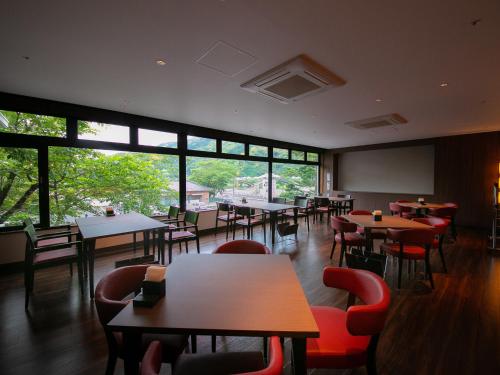 a restaurant with tables and chairs and a large window at Iwakuni Kokusai Kanko Hotel in Iwakuni