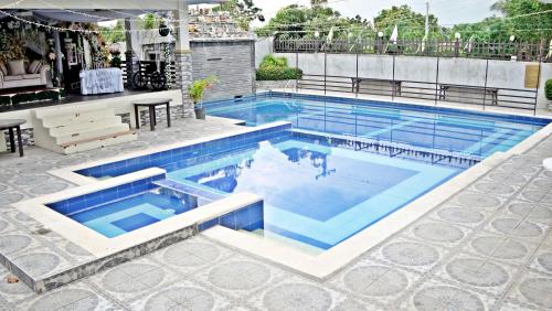 a swimming pool with blue water in a building at Villa Esmeralda Bryan's Resort Hotel and Restaurant in Palayan City