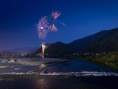 a palm tree on the beach with a fireworks display at Iwakuni Kokusai Kanko Hotel in Iwakuni