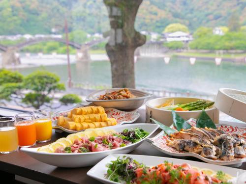 a table topped with plates of food and drinks at Iwakuni Kokusai Kanko Hotel in Iwakuni
