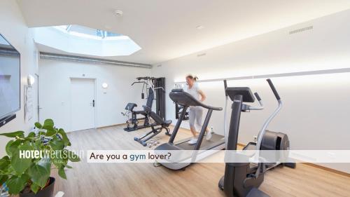 a woman exercising on a treadmill in a gym at Hotel Wettstein in Basel