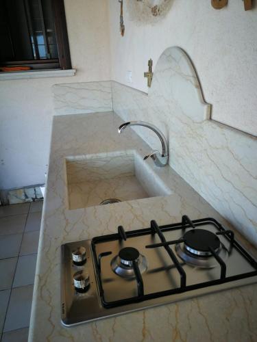 a kitchen counter with a stove and a sink at Villa Egusa in Favignana