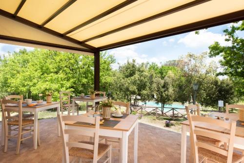 a patio with tables and chairs and a view of the water at I Pianelli in Murlo