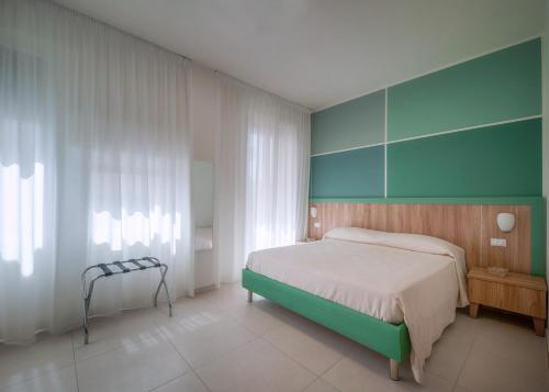 um quarto com uma cama e uma parede verde em Bed & Breakfast Sud em Gallipoli