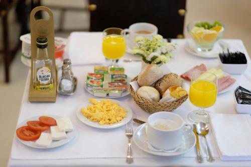 a table with breakfast foods and drinks on it at Hotel Dona Sofia in Braga