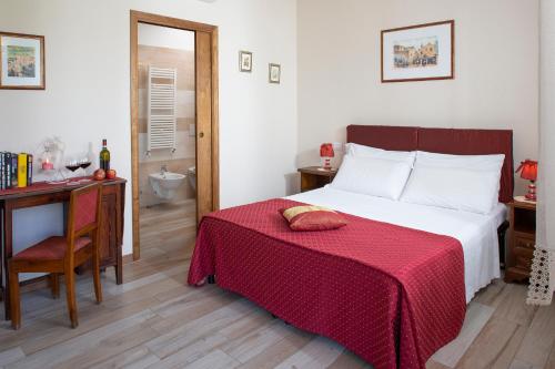 a bedroom with a bed with a red blanket on it at All'Antica Mattonata in Assisi