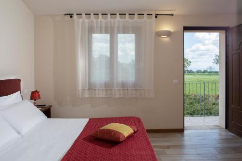 a bedroom with a bed with a red blanket and a window at All'Antica Mattonata in Assisi