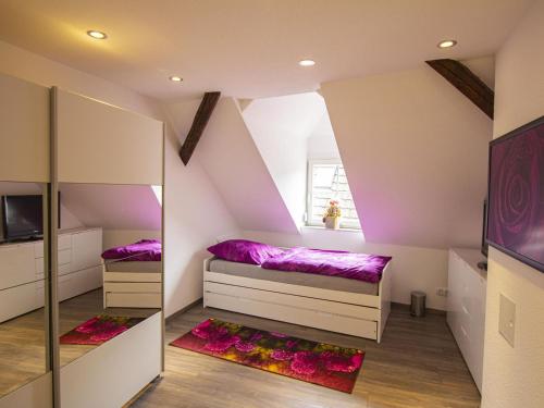 a attic bedroom with two beds and a window at Ferienwohnung Innenstadt in Oberkirch