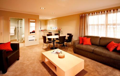 a living room with a couch and a table at TOWER JUNCTION MOTOR LODGE - Best Location - Free Pickup & Dropoff Service to Christchurch Railway Station - walking Distance to Westfield mall, Tower junction mall, Addington Raceway and Hagley Park etc in Christchurch