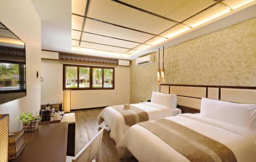 a hotel room with two beds and a window at North Zen Villas in Panglao
