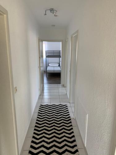a hallway with a black and white rug on the floor at Victoria Appartement in Kappel-Grafenhausen