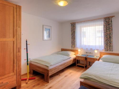 1 dormitorio con 2 camas individuales y ventana en Haus Ricarda, en Lech am Arlberg
