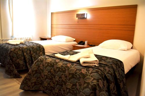 a hotel room with two beds and a wooden headboard at Bormali Hotel in Corlu