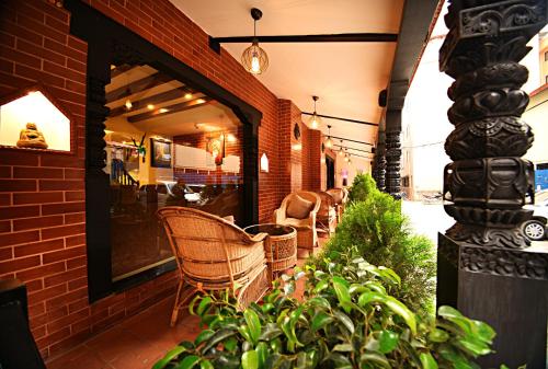 a patio with chairs and plants in front of a building at Kumari Boutique Hotel in Kathmandu