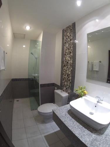 a bathroom with a sink and a toilet and a shower at Patong Mansion - SHA Certified in Patong Beach