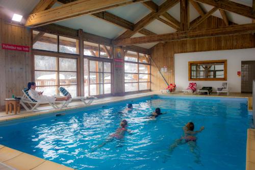 un groupe de personnes nageant dans une piscine dans l'établissement Résidence Goélia Les Chalets de Saint-Sorlin, à Saint-Sorlin-dʼArves