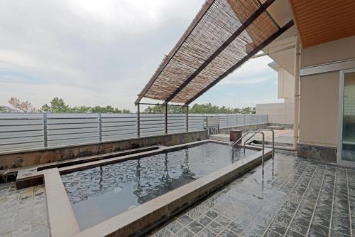 a swimming pool on a building with a roof at Kyukamura Shikanoshima in Fukuoka