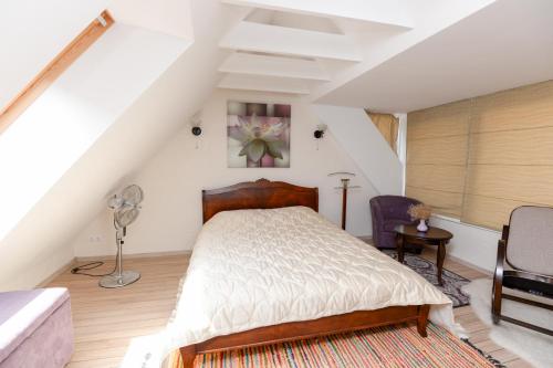ein Schlafzimmer mit einem Bett auf einem Dachboden in der Unterkunft Sunny cottage in Palanga