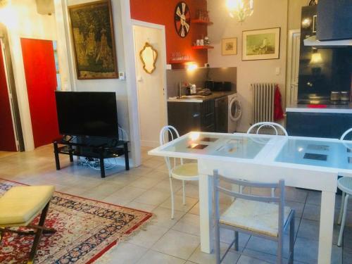 sala de estar con mesa blanca y sillas en Les Moulins de Requeugne, en Tauxigny