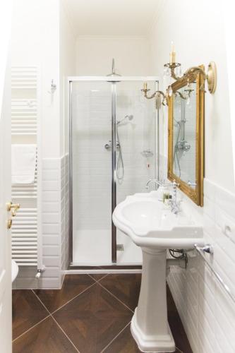 a white bathroom with a shower and a sink at Alessia's Place in Como