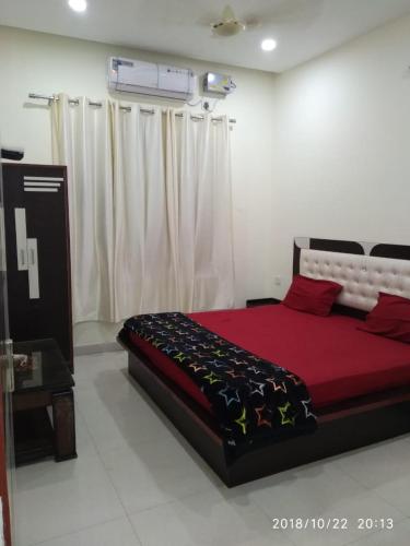 a bedroom with a large red bed in a room at Oscar Banquet and Hotel in Kālka
