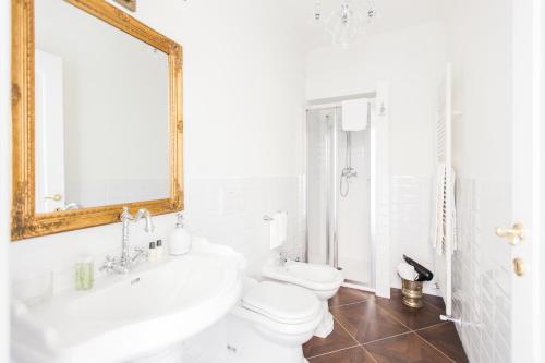 a bathroom with a sink and a toilet and a mirror at Alessia's Place in Como